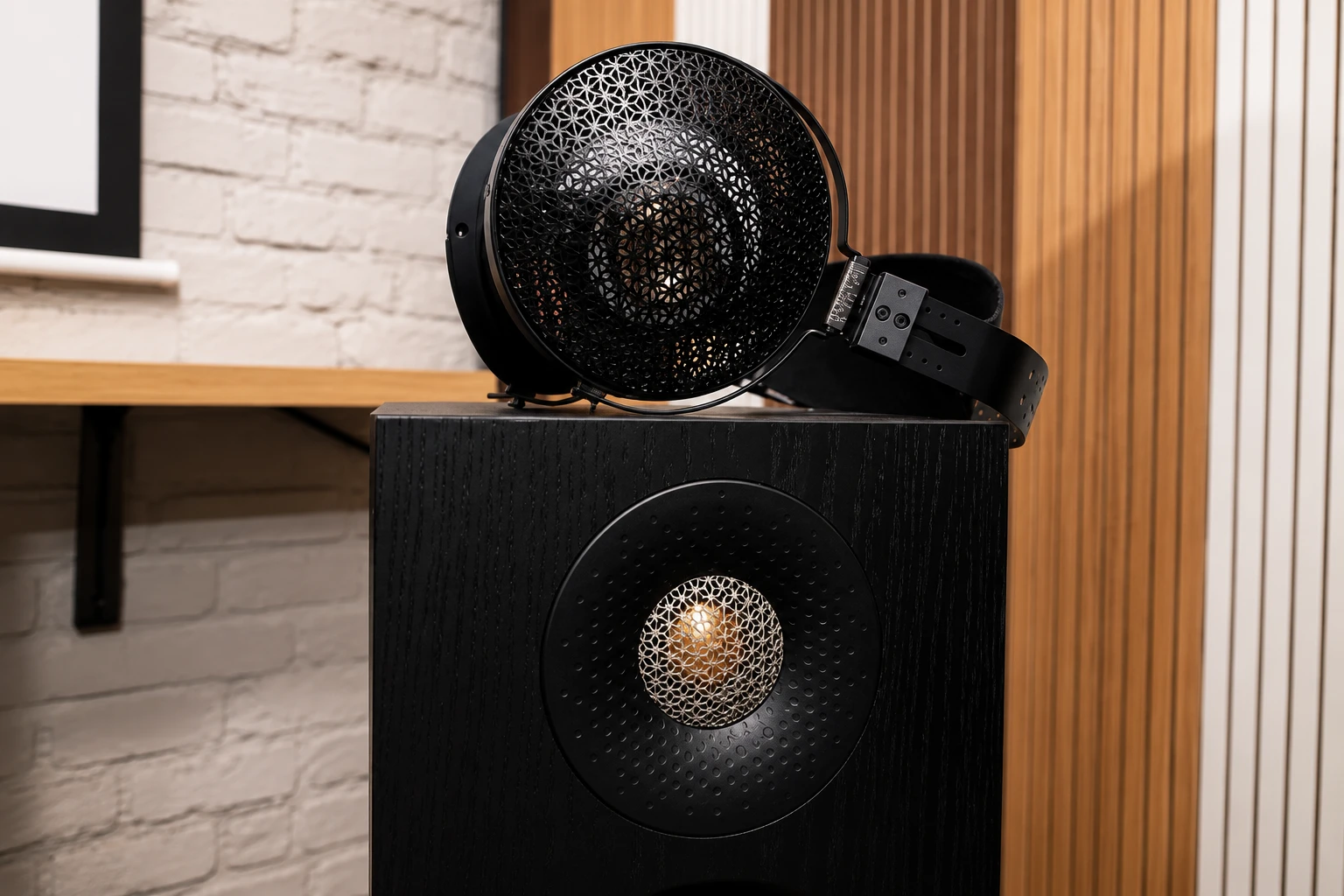 Moondrop Horizon Review: Spacious Sound and Audiophile Comfort 10 The Moondrop Horizon's striking open-back design takes center stage, showcasing its intricate metal grille and angled driver architecture. Resting atop a high-end loudspeaker, the headphones reflect the same attention to detail and acoustic craftsmanship that define their spacious, natural sound signature.